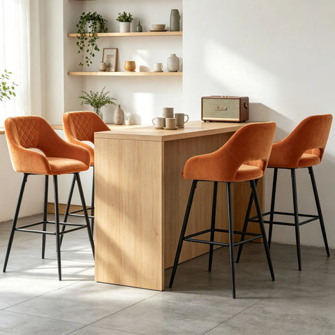Four orange velvet quilted bar stools with arms at a wooden counter