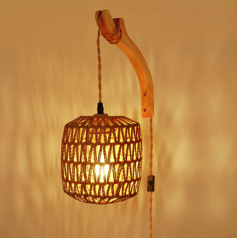 Rattan wall lamp lit, showing the woven shade pattern