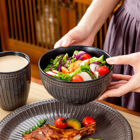 Holding a ribbed ceramic bowl filled with food