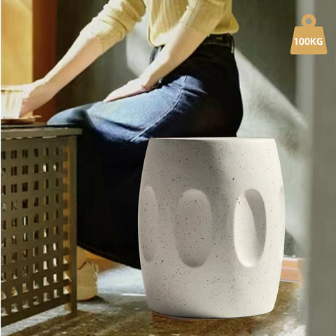 Round concrete side table on a wooden floor, close view of the moulded body