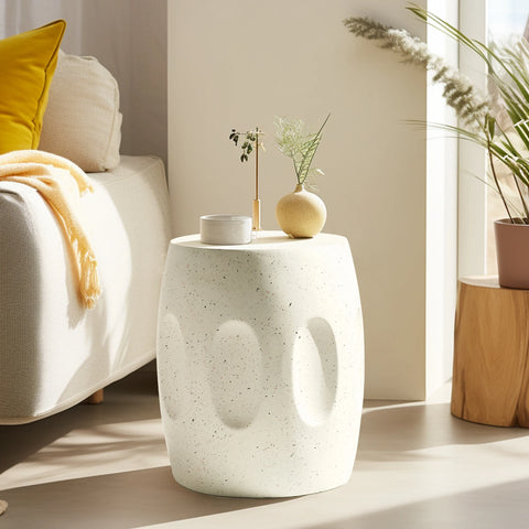 Off-white concrete side table beside a potted plant in a living room