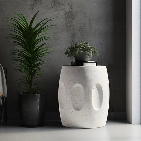 Off-white concrete side table against a dark wall with trailing plants