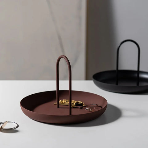 Crimson and black round handled trays holding jewellery