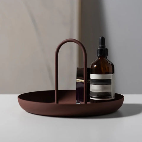 Crimson round handled tray holding a bottle and jar