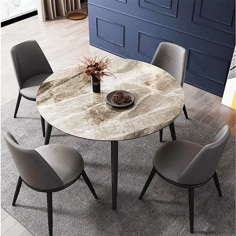 Round grey marble dining table with tapered black legs in a dining room