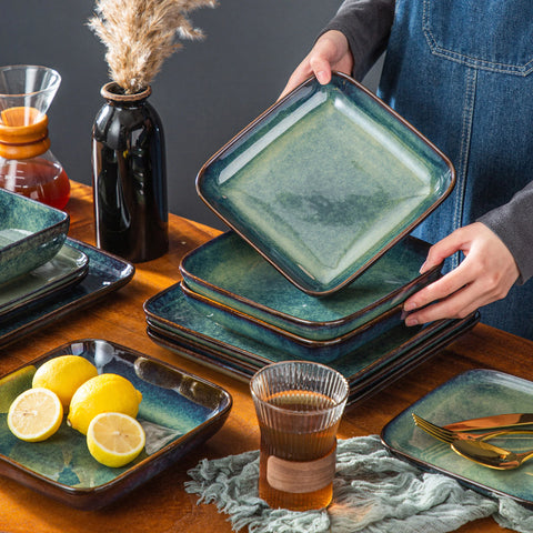 Pouring a drink beside stacked green square stoneware plates