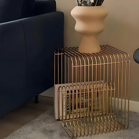 Gold wire side table beside a navy sofa