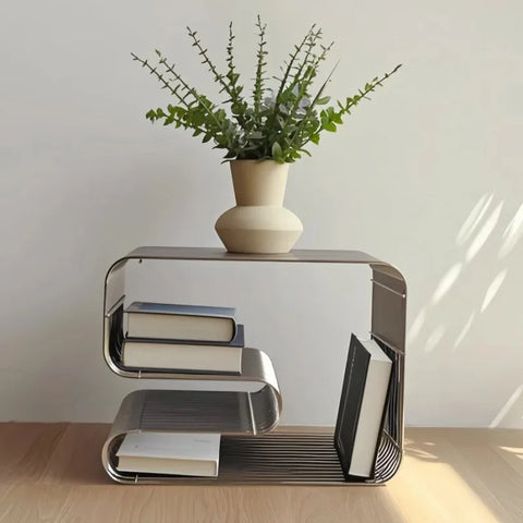 Silver wire side table holding a stack of books and a vase