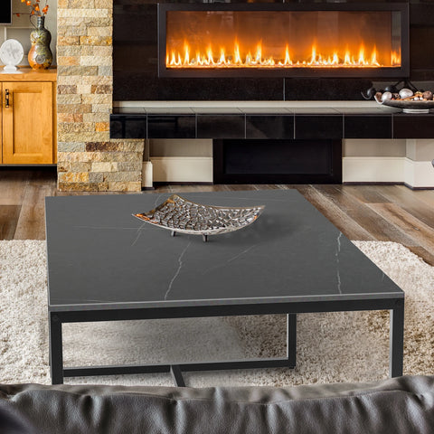 Black stone coffee table in front of a fireplace