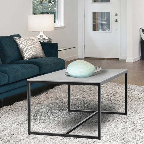 Light grey stone coffee table in front of a teal sofa