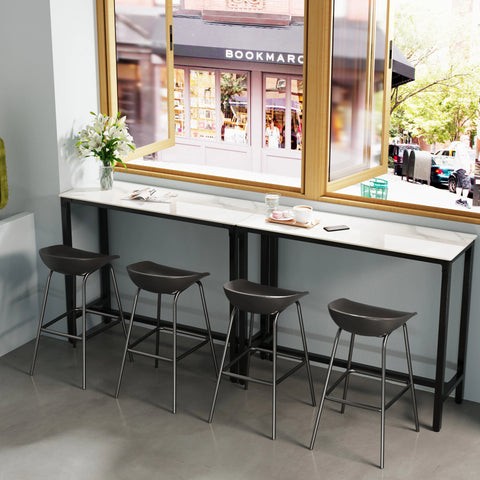 Stone top bar table with stools in front of a window
