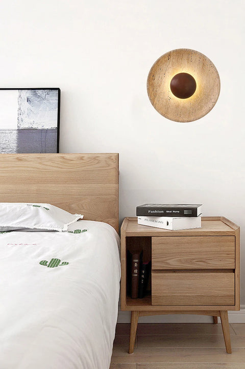 Stone and wood wall light above a bedside cabinet