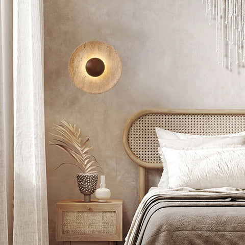 Stone and wood wall light beside a cane headboard
