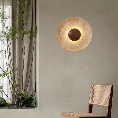 Stone and wood wall light on a plaster wall beside a chair