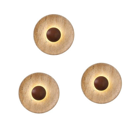 Three stone and wood wall lights arranged on a white wall