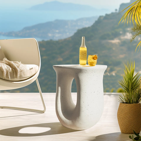 U-shaped concrete side table outdoors with plants and a view