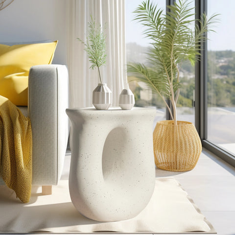 U-shaped concrete side table beside a window with a vase