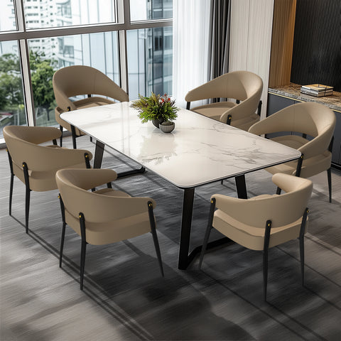Upholstered dining chairs around a marble dining table by a window