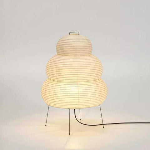 Tiered paper lantern lamp lit on a slim wire stand