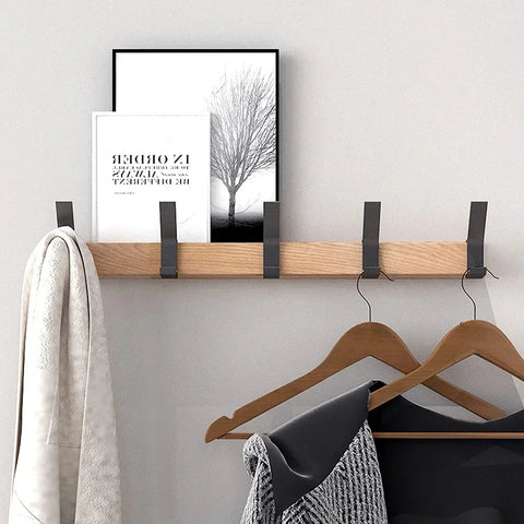 Wall-mounted coat rack with wooden hangers and folded clothes