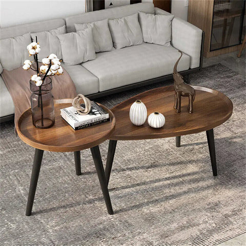 Walnut nesting coffee tables in front of a grey sofa