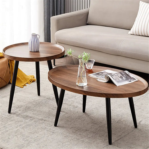 Walnut nesting coffee tables with a vase and magazines