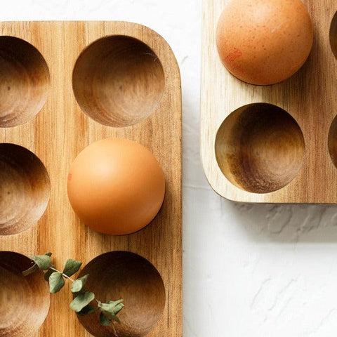 Close-up of eggs resting in the wooden egg tray