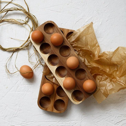 Wooden egg tray filled with eggs on brown paper