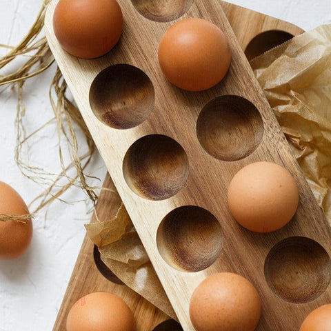Wooden egg tray with eggs and dried grasses