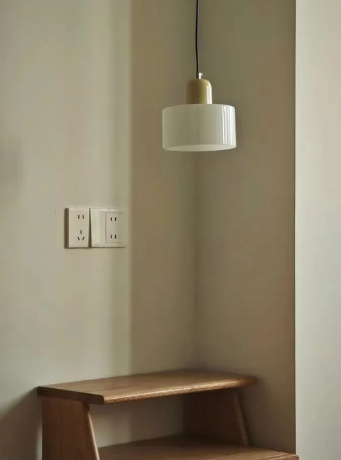 White glass pendant light above a wooden bench