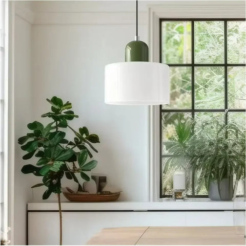 White glass pendant light with an olive cap in a kitchen by a window