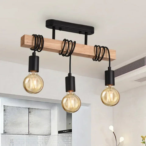 Three-bulb wooden bar pendant light hanging over a table