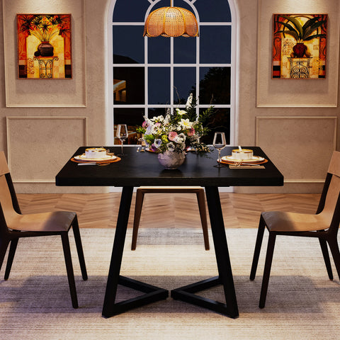 Black dining table laid for a meal in a panelled dining room