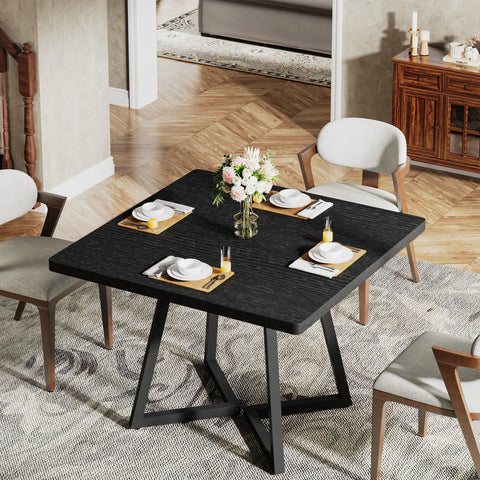 Black dining table set with plates and glassware
