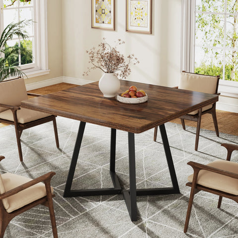 Brown wood dining table with black crossed metal legs and dining chairs
