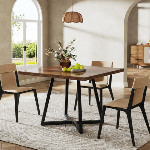 Brown wood dining table in a bright dining room with four chairs