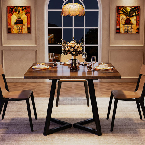 Brown wood dining table laid for a meal in a panelled dining room