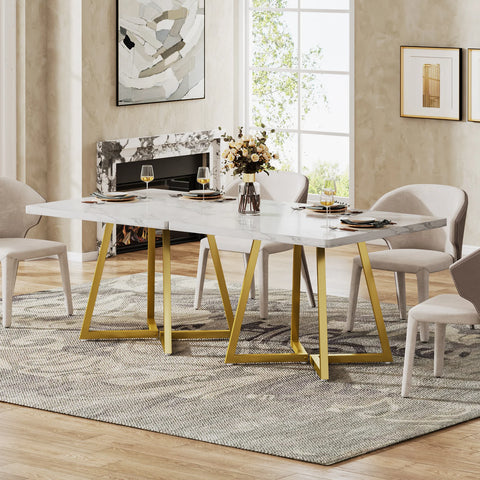 White marble dining table with gold legs beside a window
