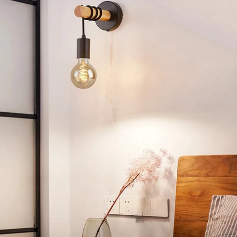 Wooden bead wall sconce lit beside an armchair