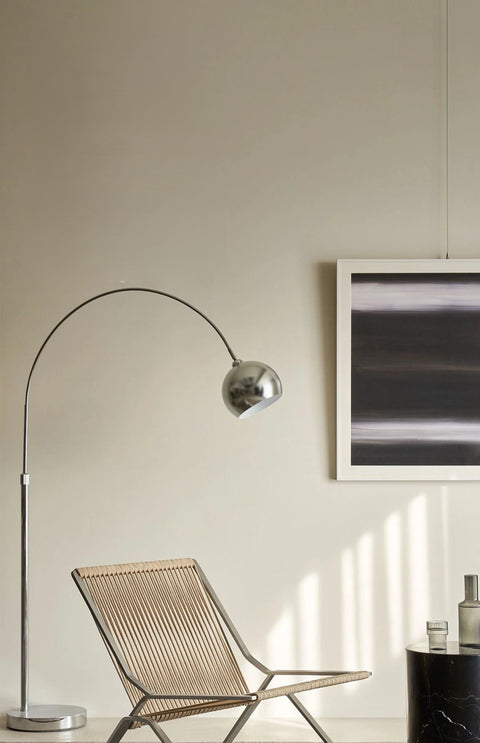 Woven cord lounge chair under an arc floor lamp