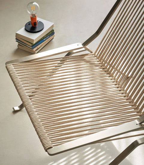 Close-up of the chair's woven cord seat and steel frame
