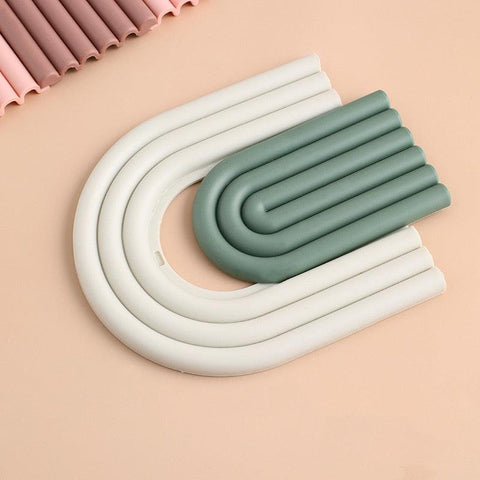 Arch-shaped coasters in cream and dark green, shown flat