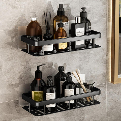 Two-tier black bathroom shelf holding bottles on a tiled wall