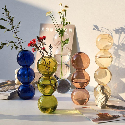 Bubble glass vases arranged with flowers and dried stems