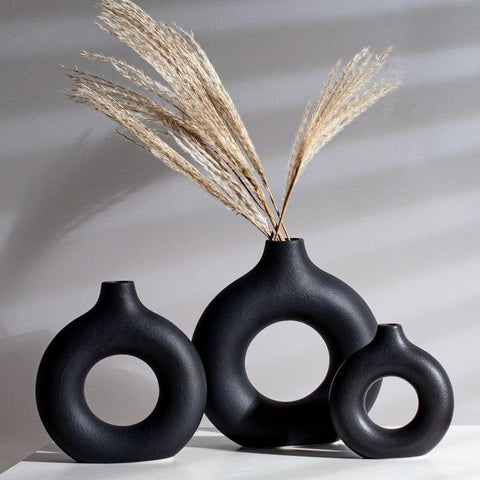 Three donut vases in black and white holding dried pampas