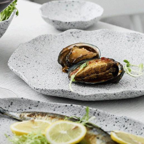 Speckled granite stoneware plate holding a served dish