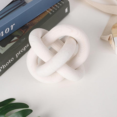 White knotted ceramic chain sculpture on a shelf