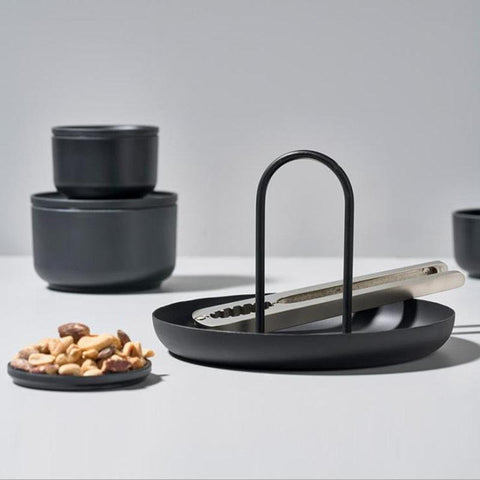Black Loop accessory tray holding a phone and glasses beside ceramic bowls