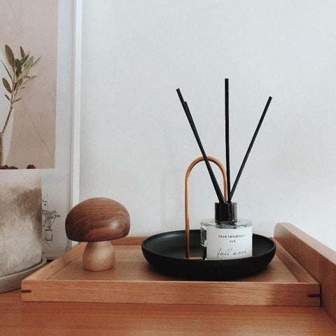 Black Loop accessory tray holding a reed diffuser on a wooden tray