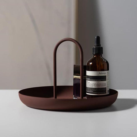 Red clay Loop accessory tray holding a dropper bottle and perfume